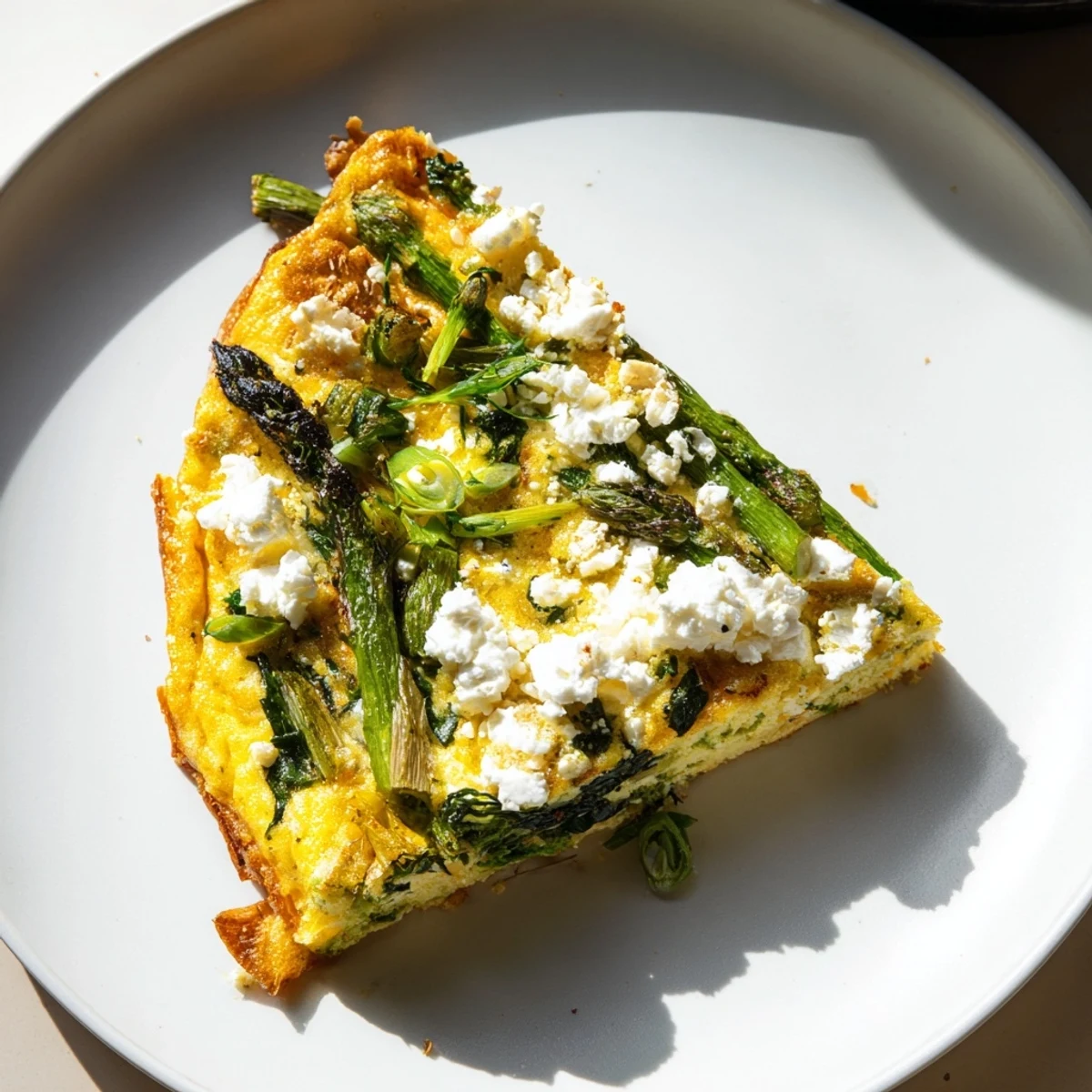 A hearty slice of Meadow-Soft Cozy Plate: Frittata showcases the creamy goat cheese and fresh veggie mix.