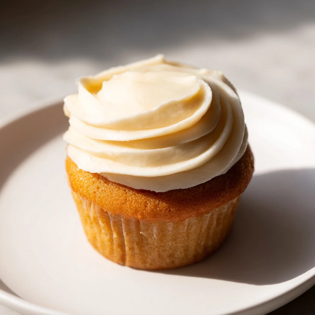 Sweet buttercream swirls atop golden, homemade vanilla cupcakes—the perfect treat to enjoy.