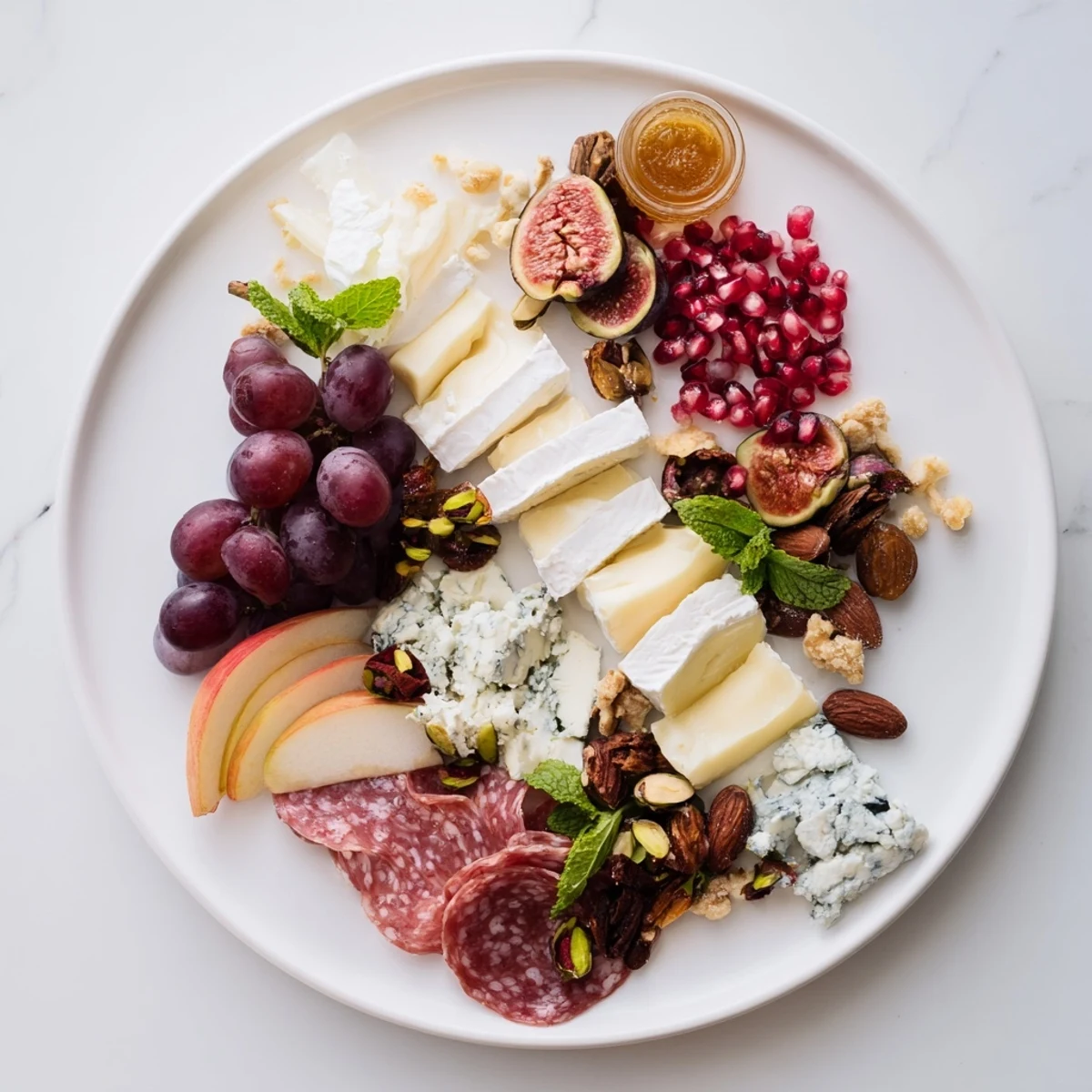 Close-up of the vibrant Pomegranate Jewel Cascade, with ruby arils glistening atop fresh fruit and cheese.