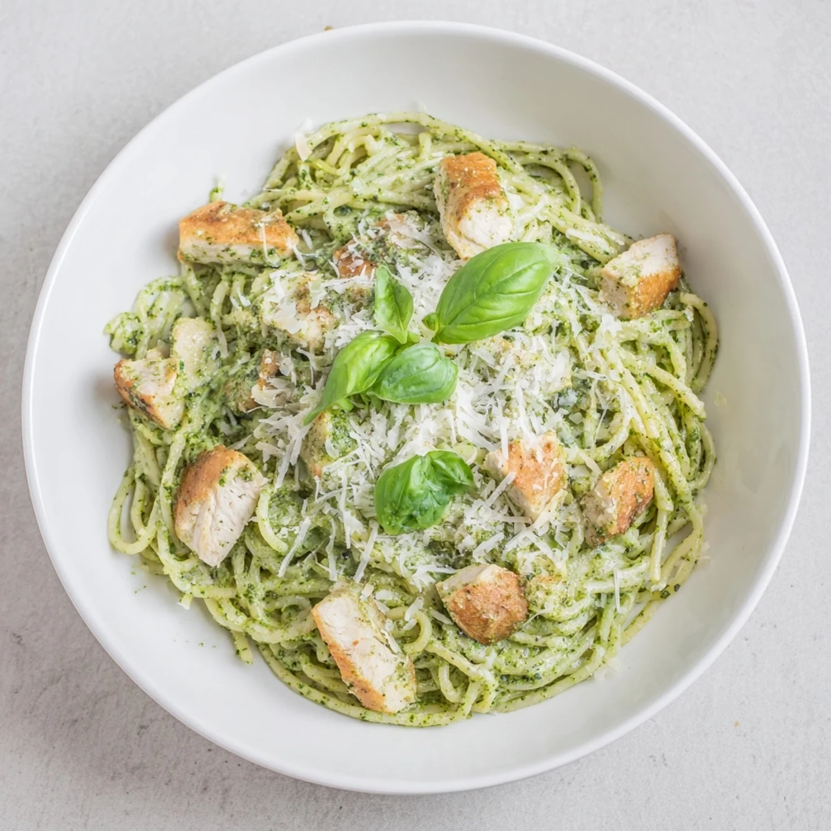 Creamy pesto egg and chicken pasta with Parmesan cheese, ready to enjoy a delicious bite!