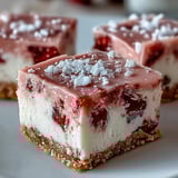 A bite-sized view of No-Bake Strawberry Fudge Squares revealing creamy pink fudge over crust.