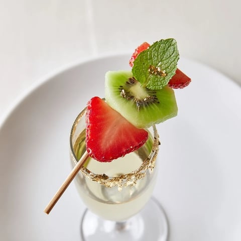 Vibrant fruit garnishes, ready to adorn champagne flutes, elevate New Years with strawberry halves.