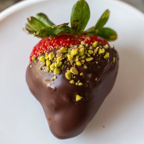 Juicy dark chocolate covered strawberry dips, a delightful dessert with optional festive sprinkles.