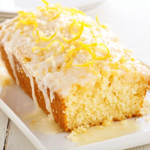 A slice of lemon loaf cake, showcasing the tender crumb and zesty lemon drizzle.