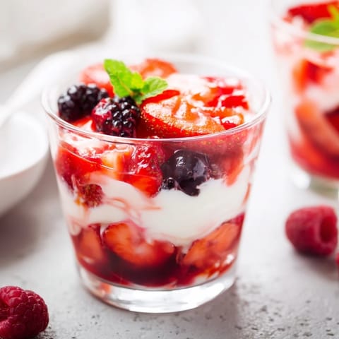 See a sweet, vibrant Berry Parfait dessert: refreshing layers of berries and homemade whipped cream.