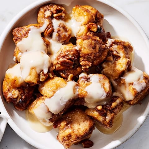 Golden-brown Cinnamon Roll Monkey Bread, a gooey pull-apart dessert with sweet caramel and icing.