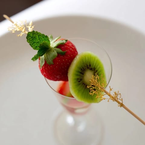 See the elegant champagne flutes topped with colorful fruit garnishes, perfect for a New Year's toast.
