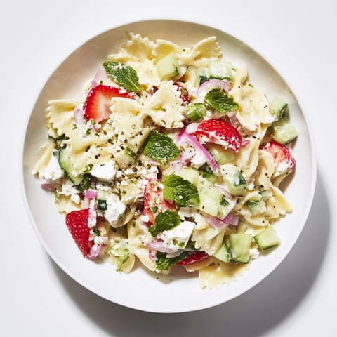 This refreshing Strawberry Feta Pasta is perfect for a summer lunch, showing colorful ingredients mixed.