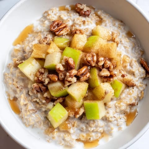 A beautiful close-up of a creamy apple pie oatmeal bowl, a comforting breakfast with cinnamon spices.