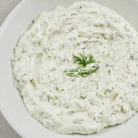 This lightened-up Greek Yogurt Ranch Dip, shown next to fresh cut vegetables, is delightfully flavorful.