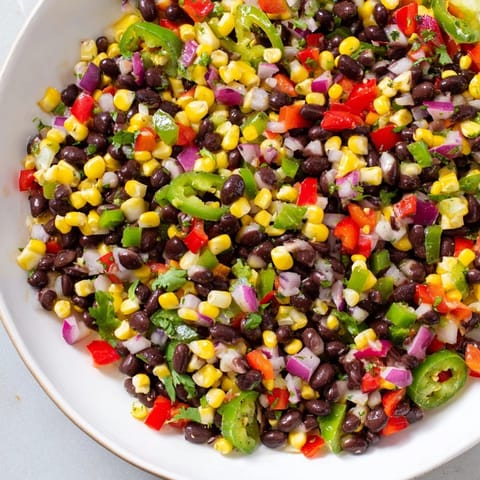 A refreshing bowl of Cowboy Caviar Salad featuring black beans, corn, and peppers, ready to eat.