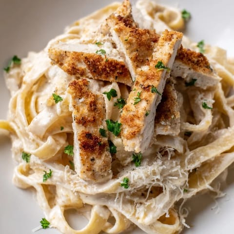 Creamy Cajun Chicken Alfredo pasta features tender chicken strips with spicy seasoning over a rich, velvety sauce.  