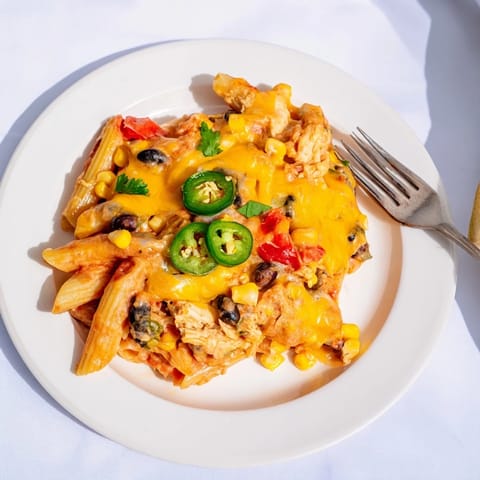 A spoonful of Tex-Mex Chicken Burrito Pasta Bake reveals chicken, black beans, and corn.