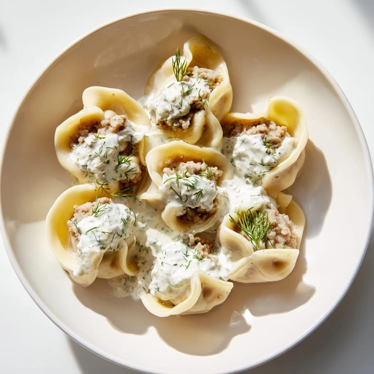 A close-up of golden, cooked Russian pelmeni, showing the savory, seasoned meat filling.