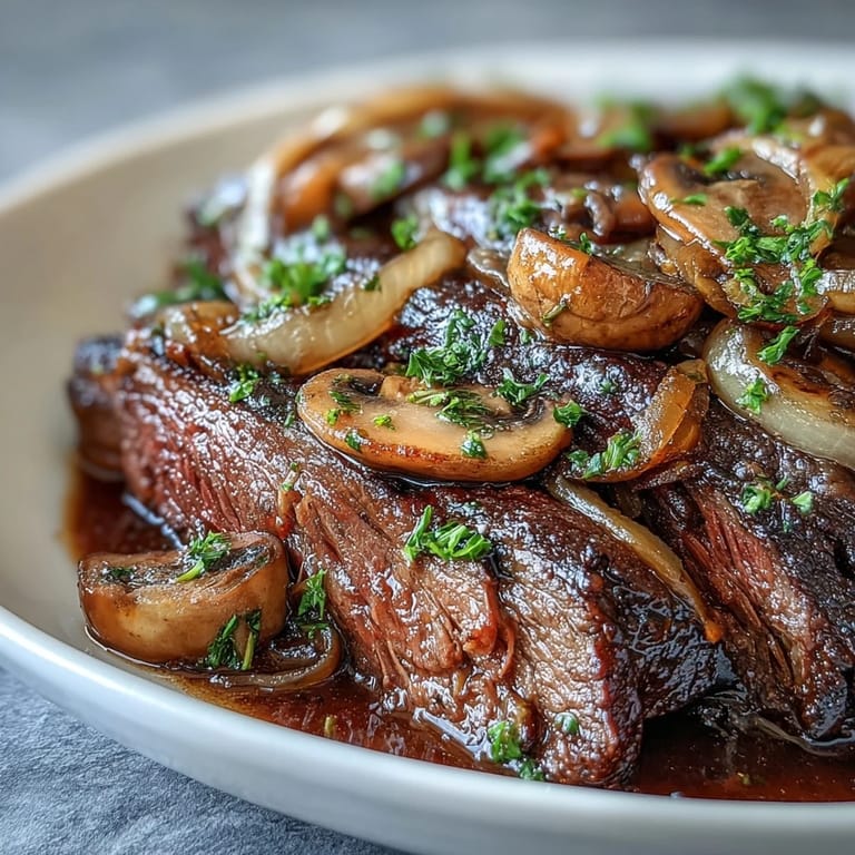 Savory Crock Pot French Onion Pot Roast served in a bowl with mushrooms and thyme, ideal for a cozy family dinner.