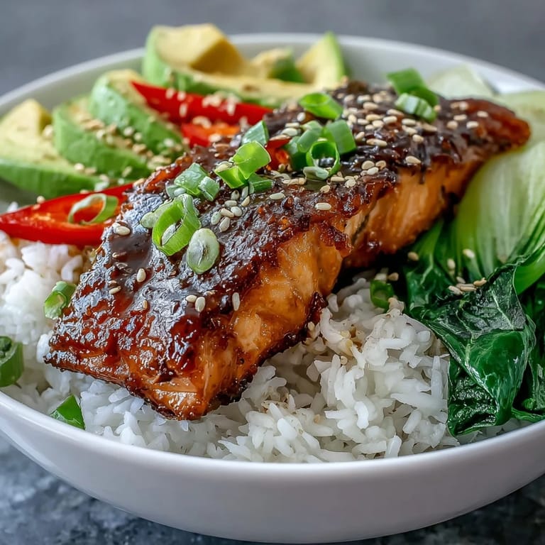 Bright lime wedges accompany a wholesome Soy Ginger Salmon Bowl, featuring glazed fillet and crisp Asian veggies.