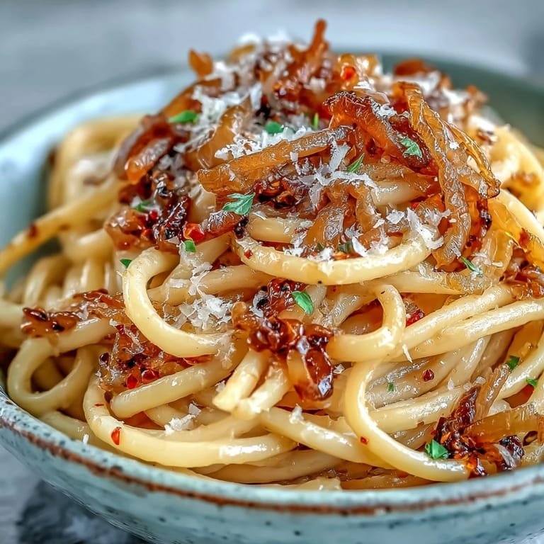 Pasta twirled on a fork with glistening chili oil, served alongside a glass of white wine.