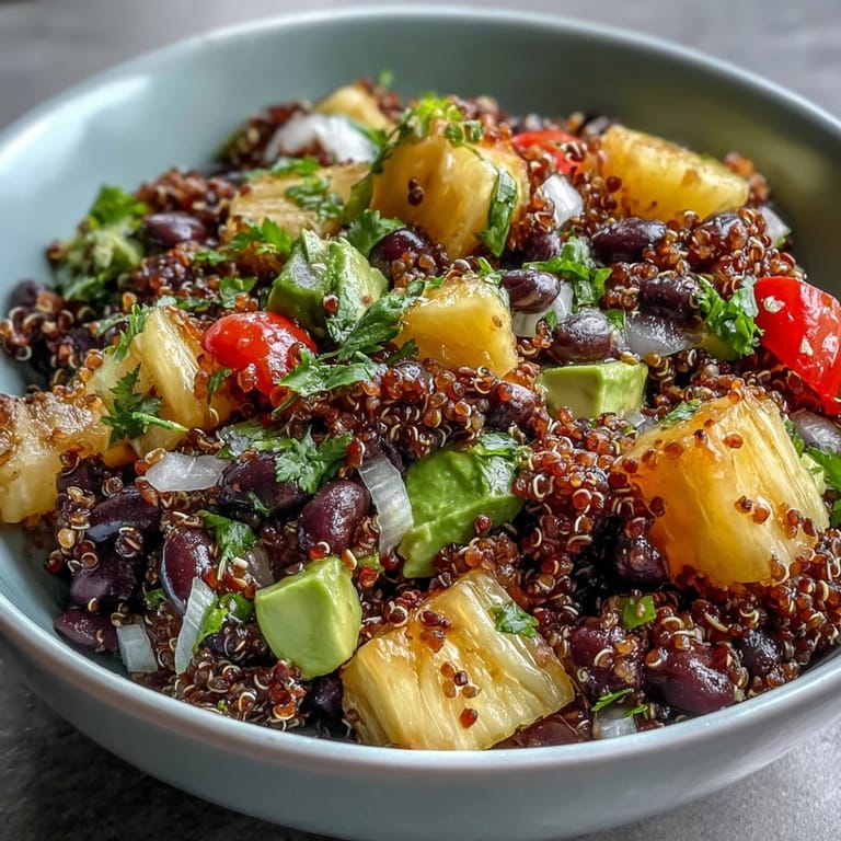 Colorful serving of Tropical Quinoa Salad with Pineapple and Black Beans featuring diced avocado and drizzled zesty lime dressing.